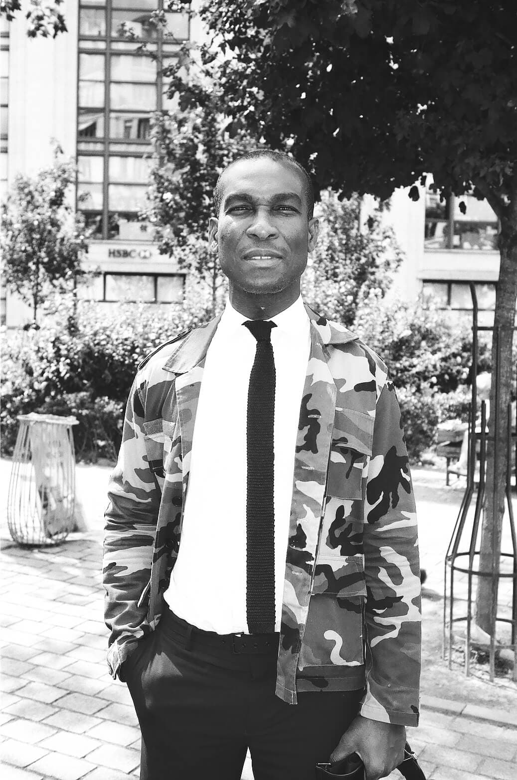 Barthelemy de Mazenod | People of Paris | The portrait of handsome man wearing a white shirt, a black tie and a camo jacket