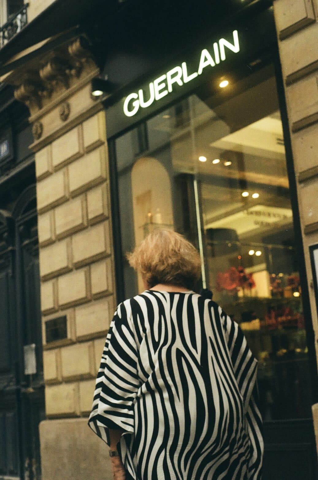 Barthelemy de Mazenod | People of Paris | An old woman wearing a zebra dress in front of a Gerlain store