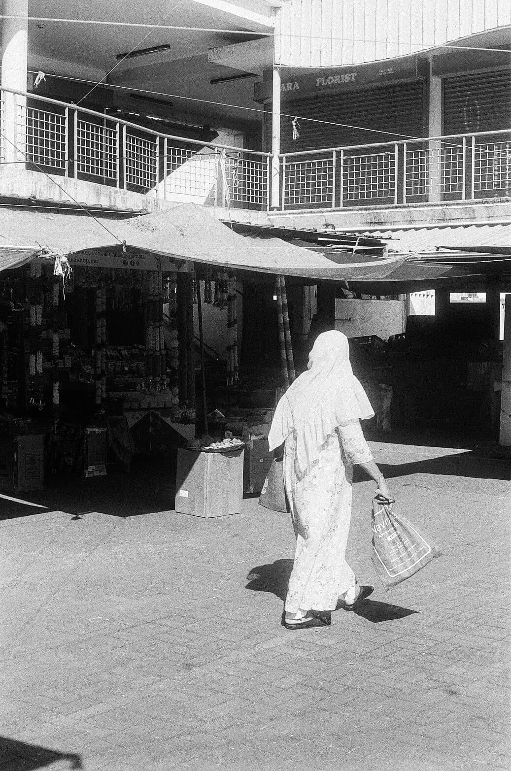 Barthelemy de Mazenod | Travel | A woman walking in a farmer's market in Mauritius